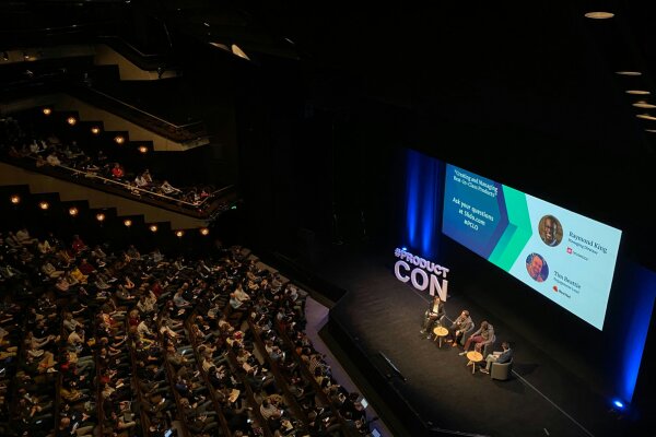 Conférence professionnelle dans un grand auditorium avec intervenants sur scène